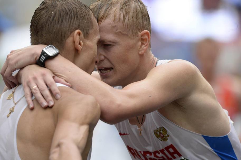 Due medaglie per una nazione: i russi Ivanov e Strelkov si abbracciano stremati dopo la fine della 20km di marcia, chiusa al secondo e terzo posto. Epa